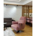 Розова фотеља во модерно уредена дневна соба со дрвени летви / Pink armchair in a modern living room with wooden slats.