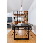 Поглед од трпезариска маса кон ТВ зона со стаклена преграда во индустриски стил / View from dining table towards a TV zone with an industrial glass partition.