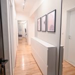 Long hallway perspective with a white console and mirror