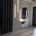 Decorative black slats with a round mirror and lighting