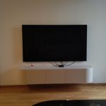 Минималистичка бела лебдечка ТВ комода на ѕид / Minimalist white floating TV cabinet on a wall.