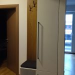 плакар со вградено седиште и долга црна рачка во ходник