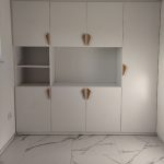 Бел вграден плакар со шест уникатни дрвени рачки во аголна форма